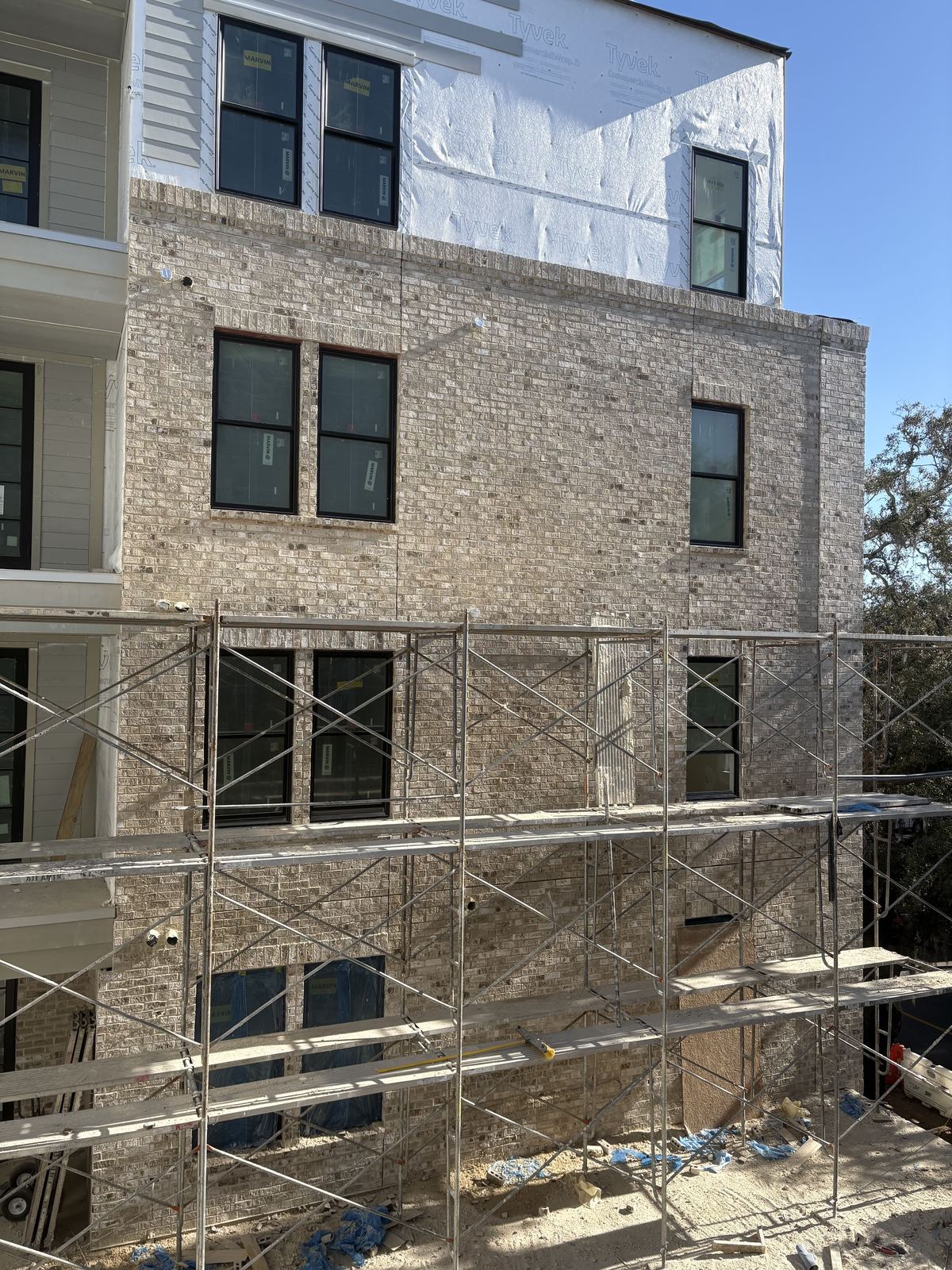 ANJ Construction crew's brick veneer facade on a multifamily building in Savannah, Georgia, with scaffolding still up