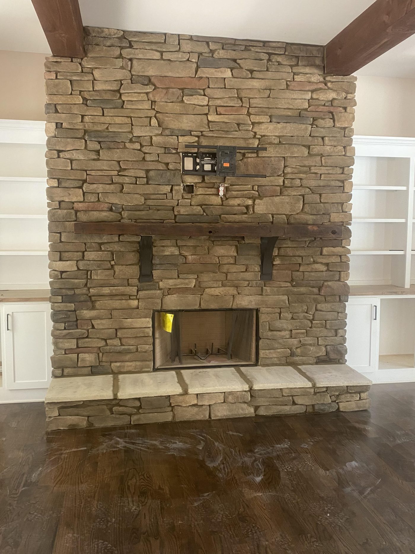 Floor-to-ceiling stacked stone fireplace with a timber mantel and stone hearth seat in a Winder, Georgia home